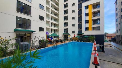 a swimming pool in front of a building at Deluxe Queen Studio with swimming pool in Nairobi, Himalaya Heights Apartment, Kilimani in Nairobi