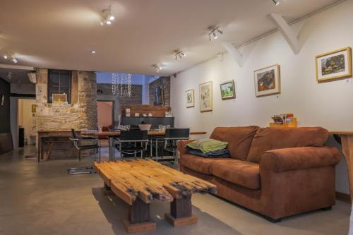 uma sala de estar com um sofá e uma mesa em Galerie Nakai Art B&B em Tournus