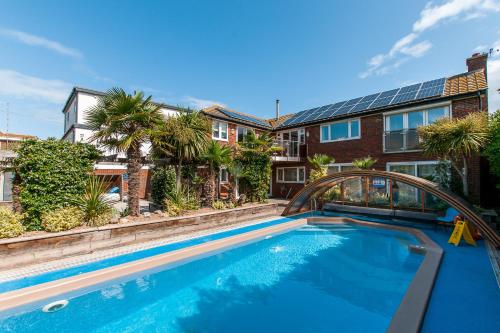 a swimming pool with a bridge in front of a building at Botany Bay Beach House - Stunning Sea Views in Kingsgate