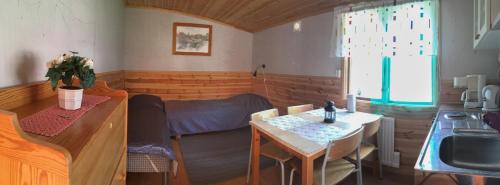 a room with a kitchen and a table and a sink at Haga gård och Stall in Herräng