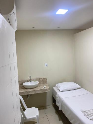 a small room with a bed and a sink at Hotel Renascer pojuca in Pojuca