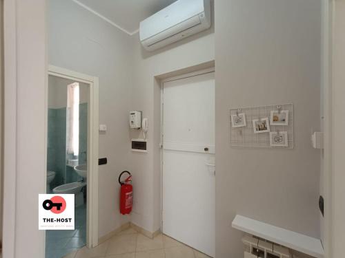 a white room with a refrigerator and a fire extinguisher at Vimodrone, modern accommodation near San Raffaele in Vimodrone