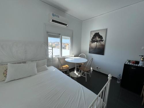 ein Schlafzimmer mit einem großen weißen Bett und einem Tisch in der Unterkunft Krezias Apartments K1 Acropolis View! in Athen