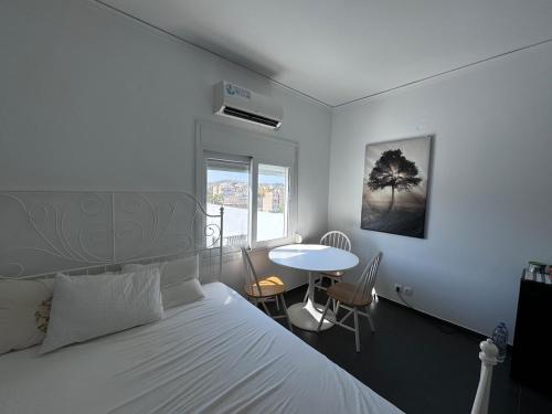 ein Schlafzimmer mit einem Bett und einem Tisch und einem Fenster in der Unterkunft Krezias Apartments K1 Acropolis View! in Athen