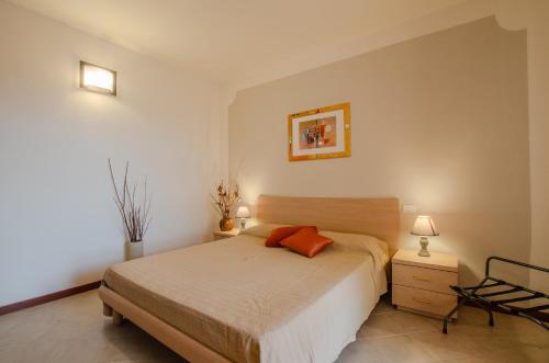 - une chambre dotée d'un lit avec deux oreillers orange dans l'établissement Residence Cernaia - Private Cottage, à Castiglione della Pescaia