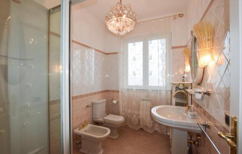 ein Badezimmer mit Waschbecken, WC und Kronleuchter in der Unterkunft Villa Sophia by Nicola Real Estate in Corsanico-Bargecchia
