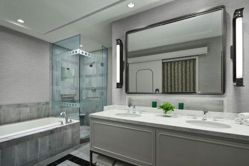 a bathroom with two sinks and a tub and a mirror at The Ritz-Carlton, Charlotte in Charlotte