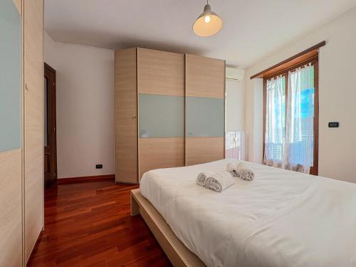Un dormitorio con una gran cama blanca con dos toallas. en MYHOUSE INN RACCONIGI - Affitti Brevi Italia, en Turín