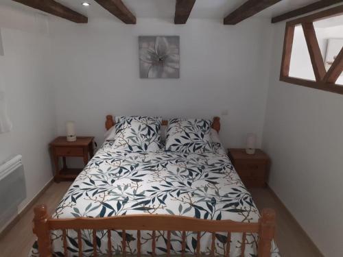 a bedroom with a bed with a white and black comforter at Chez Loulou du Linas - Bugarach in Bugarach
