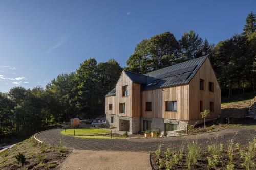 une maison de style grange sur une colline avec une route dans l'établissement Apartmány Hraničná s privátním wellness, à Bedřichov