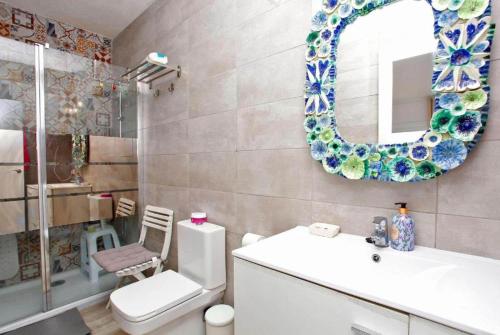 ein Badezimmer mit Toilette, Waschbecken und Spiegel in der Unterkunft Villa Maria de Bonaire in Alcanada