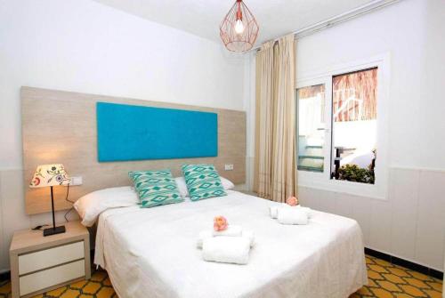 ein Schlafzimmer mit einem großen weißen Bett mit blauen Kissen in der Unterkunft Villa Maria de Bonaire in Alcanada