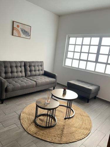 a living room with a couch and two tables at Oasis en La Condesa in Mexico City