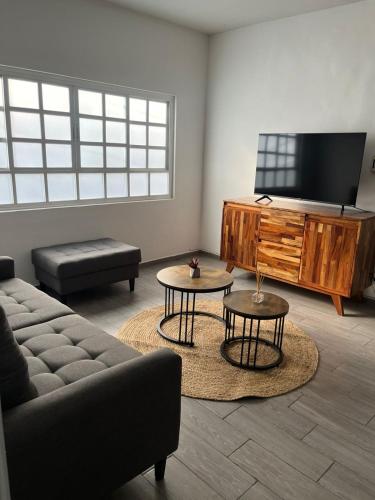 a living room with a couch and a flat screen tv at Oasis en La Condesa in Mexico City