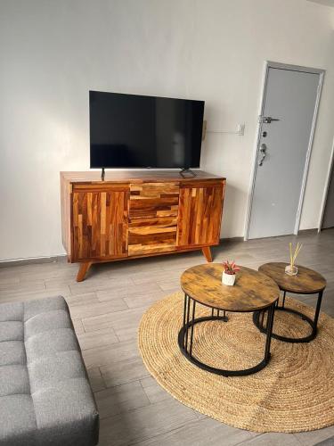 a living room with a tv and a couch and a table at Oasis en La Condesa in Mexico City