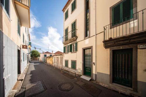 an empty street in an alley between two buildings at Sun & Roses in Funchal