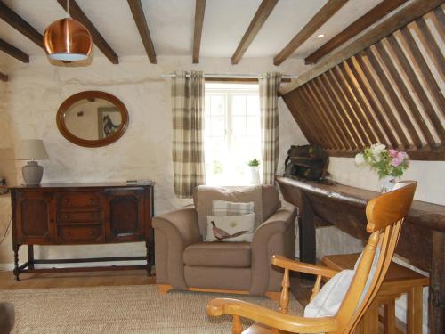 ein Wohnzimmer mit einem Stuhl und einem Klavier in der Unterkunft Shire Cottage in Highpeak Junction