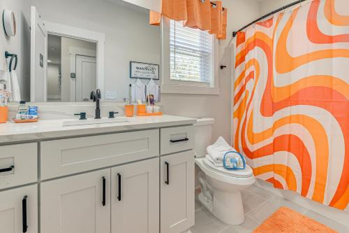 uma casa de banho laranja e branca com um WC e um lavatório em Hot Tub and Fire Pit Home Near Dtwn Little River! em Little River