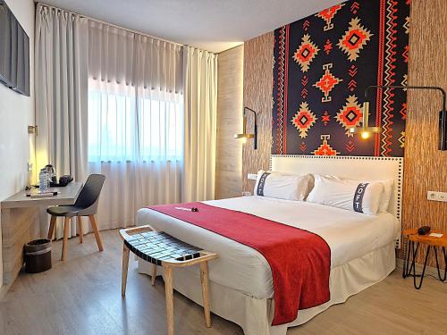 a bedroom with a large bed with a red blanket at Casual Inca Porto by Casual Hoteles in Porto