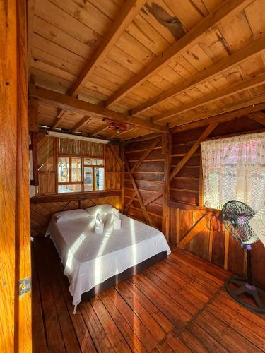ein Schlafzimmer mit einem Bett in einer Holzhütte in der Unterkunft Wila House Rural in Gigante