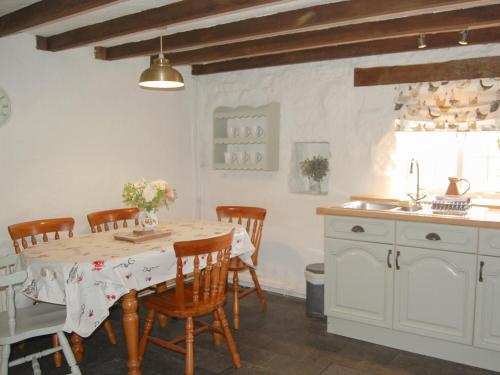 eine Küche mit Tisch und Stühlen in einem Zimmer in der Unterkunft Shire Cottage in Highpeak Junction