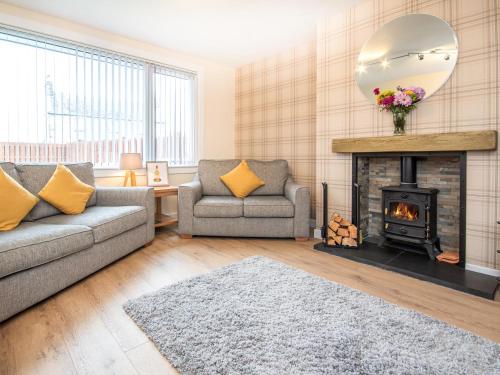 a living room with a couch and a fireplace at Colbheinn Cottage in Brora