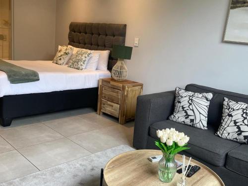 a living room with a bed and a couch and a table at Zimbali Lakes Boulevard Suites 145 in Ballito