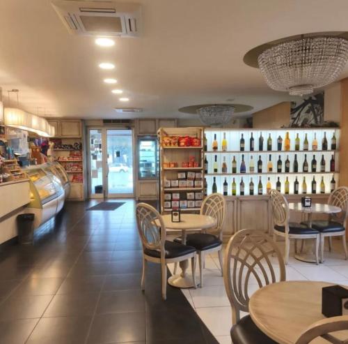 un restaurante con mesas y sillas y una estantería de botellas de vino en La Casetta. Feel at home., en Castelfidardo