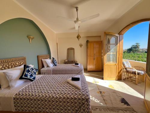 ein Schlafzimmer mit zwei Betten und einem offenen Durchgang in der Unterkunft Dar Lina Guesthouse Luxor in Luxor