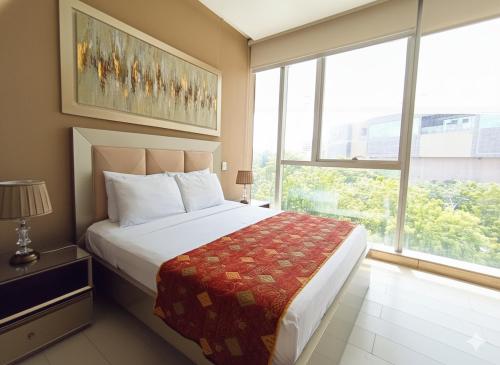 a bedroom with a large bed and a large window at Rams apartasuits en hotel 5 estrellas in Barranquilla