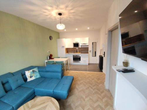 a living room with a blue couch and a kitchen at Appartement spacieux in Lille