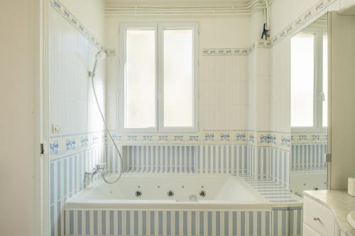 eine Badewanne im Bad mit Fenster in der Unterkunft Parisian Escape and Jacuzzi and green Vibes in Paris