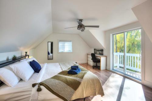 圣乔维特Centenary Lakefront 5 Bedroom Home with Hot Tub的一间卧室，里面有一张床和一扇大窗户。