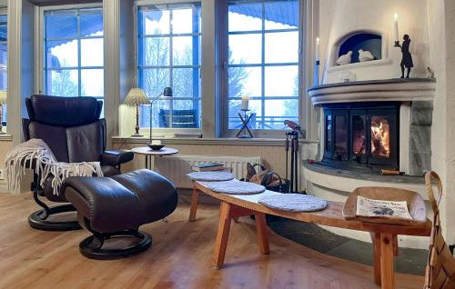 a living room with a fireplace and a table and a chair at Lovely Home In Åre With Sauna in Härbyste