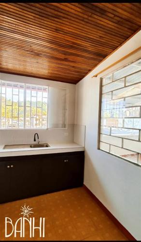 a kitchen with a sink and a window at Hospedaje Banhi in Líbano