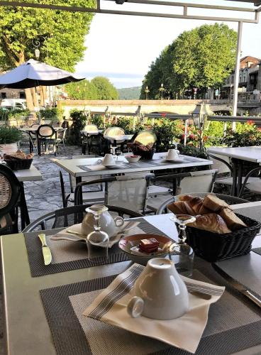 una mesa con platos de comida encima en Hôtel des Bains, en Figeac