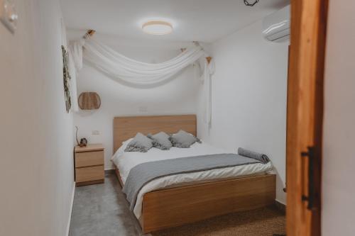 ein Schlafzimmer mit einem Bett in einem weißen Zimmer in der Unterkunft רגע בזמן - Moment in time in Arad