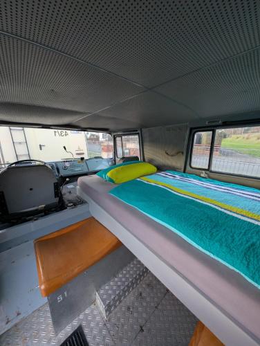 a bed in the back of a van at Oldtimer Camp Main Spessart in Collenberg