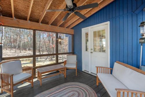 a porch with chairs and a table and a ceiling fan at Dog-Friendly Chalet in The Woods Resort w Fire Pit in Baxter