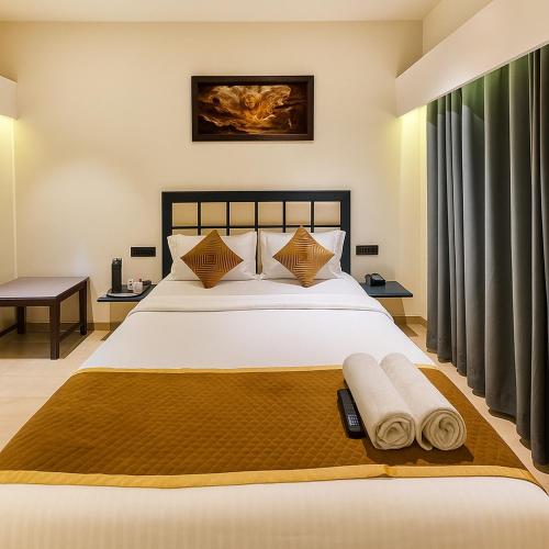 a bedroom with a large bed with towels on it at 3 BHK Mount Villa by Asmeera Stays in Lonavala