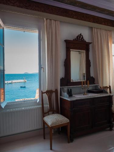 a bathroom with a sink and a mirror and a window at Kokkari Traditional House in Kokkari