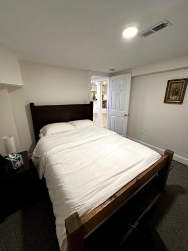 a bedroom with a large bed with white sheets at Elegant Garden Suite Minutes Walk to Union Market and NoMa Metro in Washington, D.C.