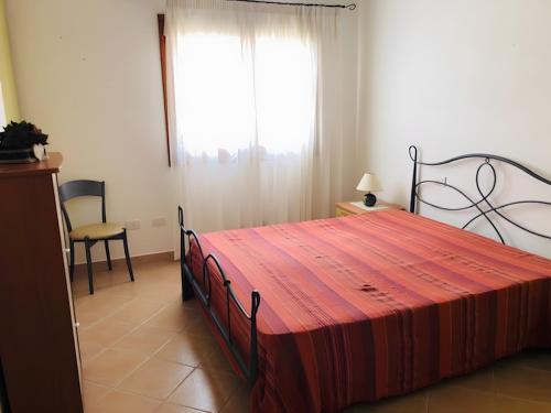 a bedroom with a large bed and a window at Trilocale I Graniti San Teodoro in Monte Petrosu