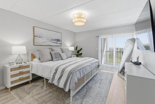 a white bedroom with a bed and a window at Bermuda Run 10 in Saint Augustine Beach