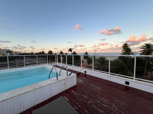 ein Swimmingpool auf einem Gebäude mit Blick auf das Meer in der Unterkunft Puerto Ventura 403 · Puerto Ventura - Beira Mar na Orla de Cabo Branco in Tambaú