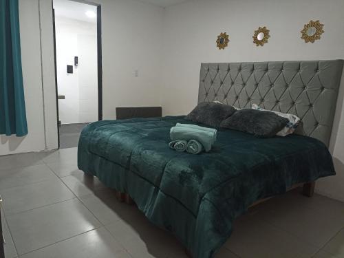 une chambre avec un lit avec une couette verte dans l'établissement Cómoda habitación, à Pátzcuaro
