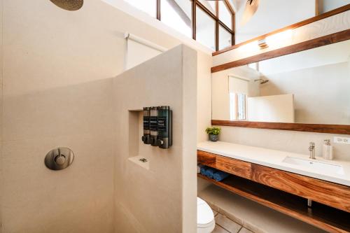 Un baño con lavabo e inodoro en Newly Remodeled Villa Across From The Beach, en Tamarindo