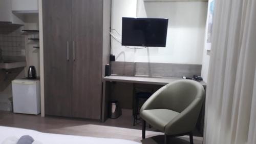 a bedroom with a desk with a chair and a television at STOP Mar Suite Privada - NI in Nova Iguaçu