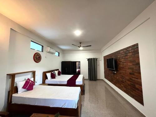 a hotel room with two beds and a tv at Lokosha Resort - The Green Destination in Hatikhuli