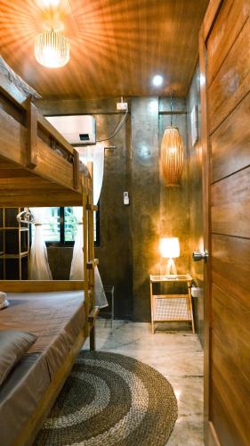 a bedroom with a bunk bed and a table with a lamp at O-ya Homestay in General Luna